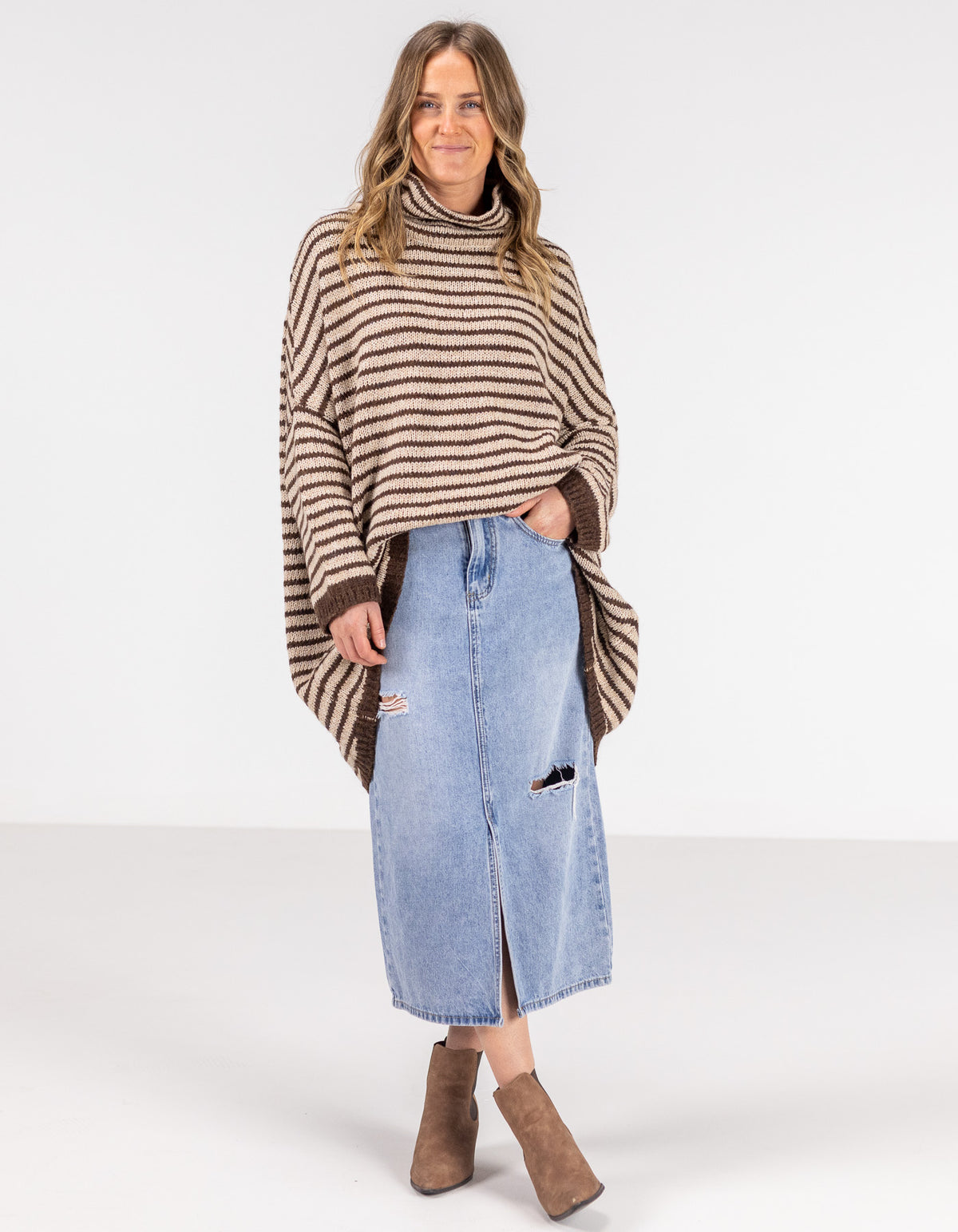 Full-length view of the Karma Kameleon chocolate and beige stripe knitwear paired with a blue denim skirt.