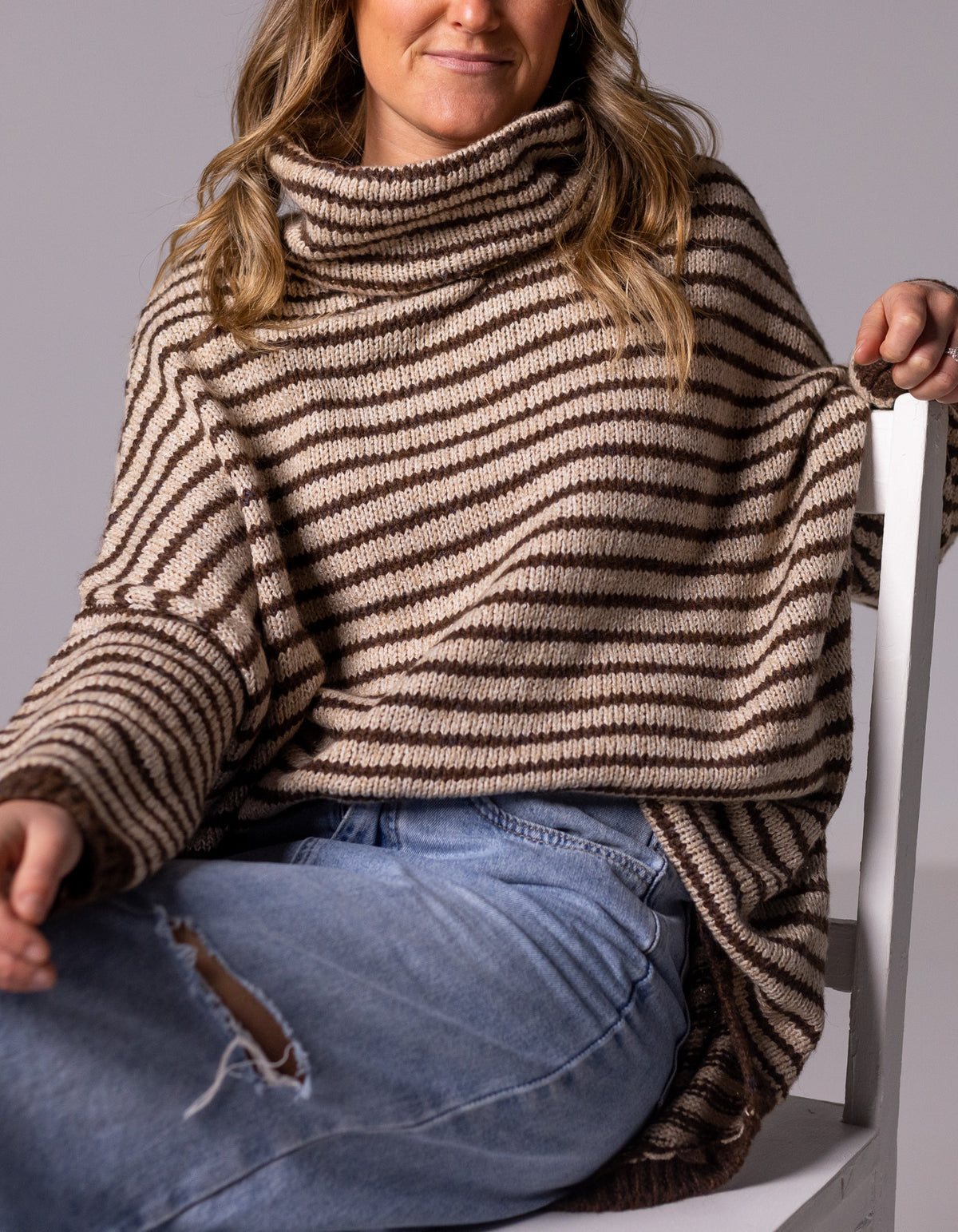 Front half-body shot of the chocolate and beige stripe jumper highlighting the relaxed drop-shoulder sleeves.