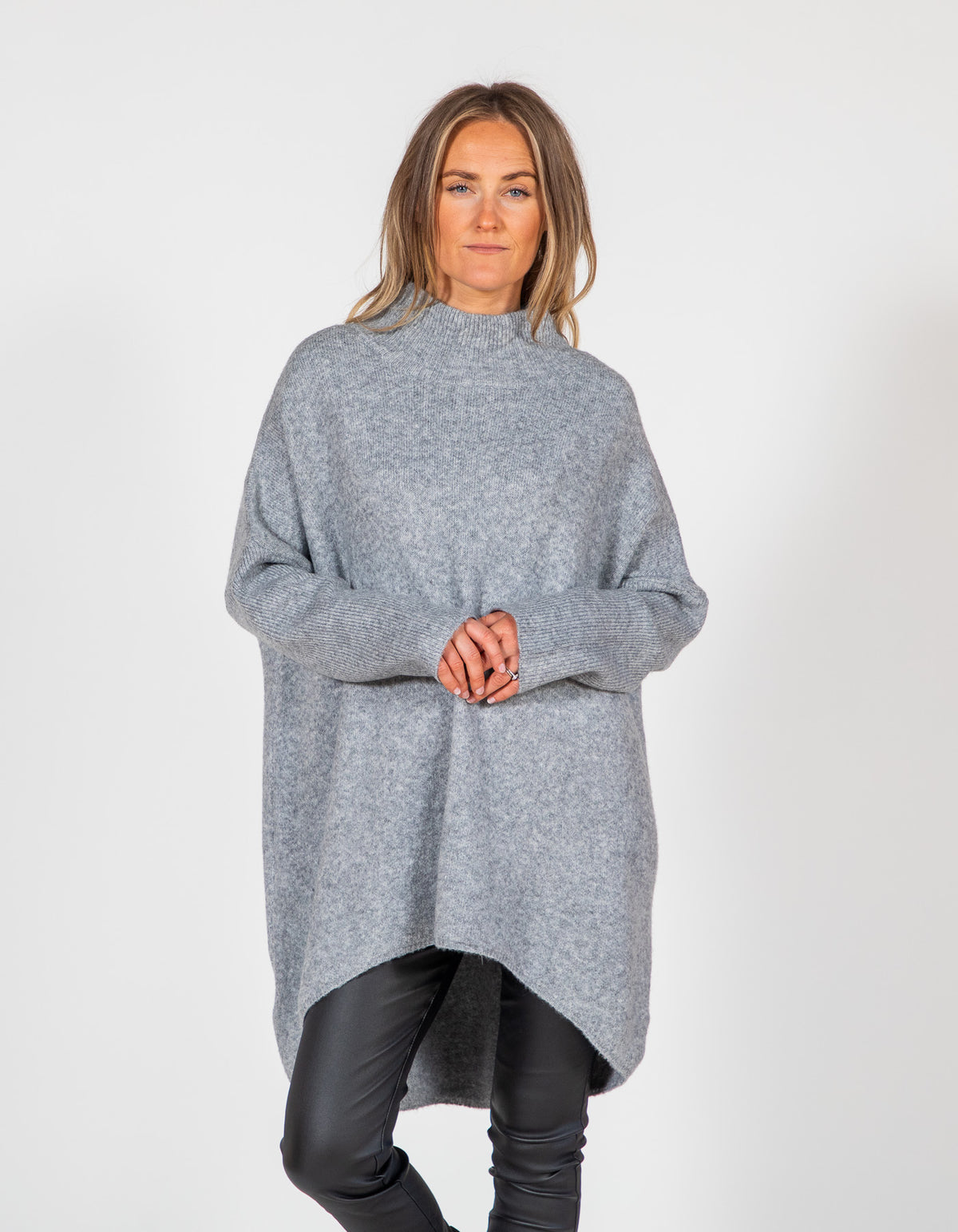 Oversized grey brushed knit jumper featuring a ribbed funnel neck, long ribbed sleeves, and a high-low hemline.