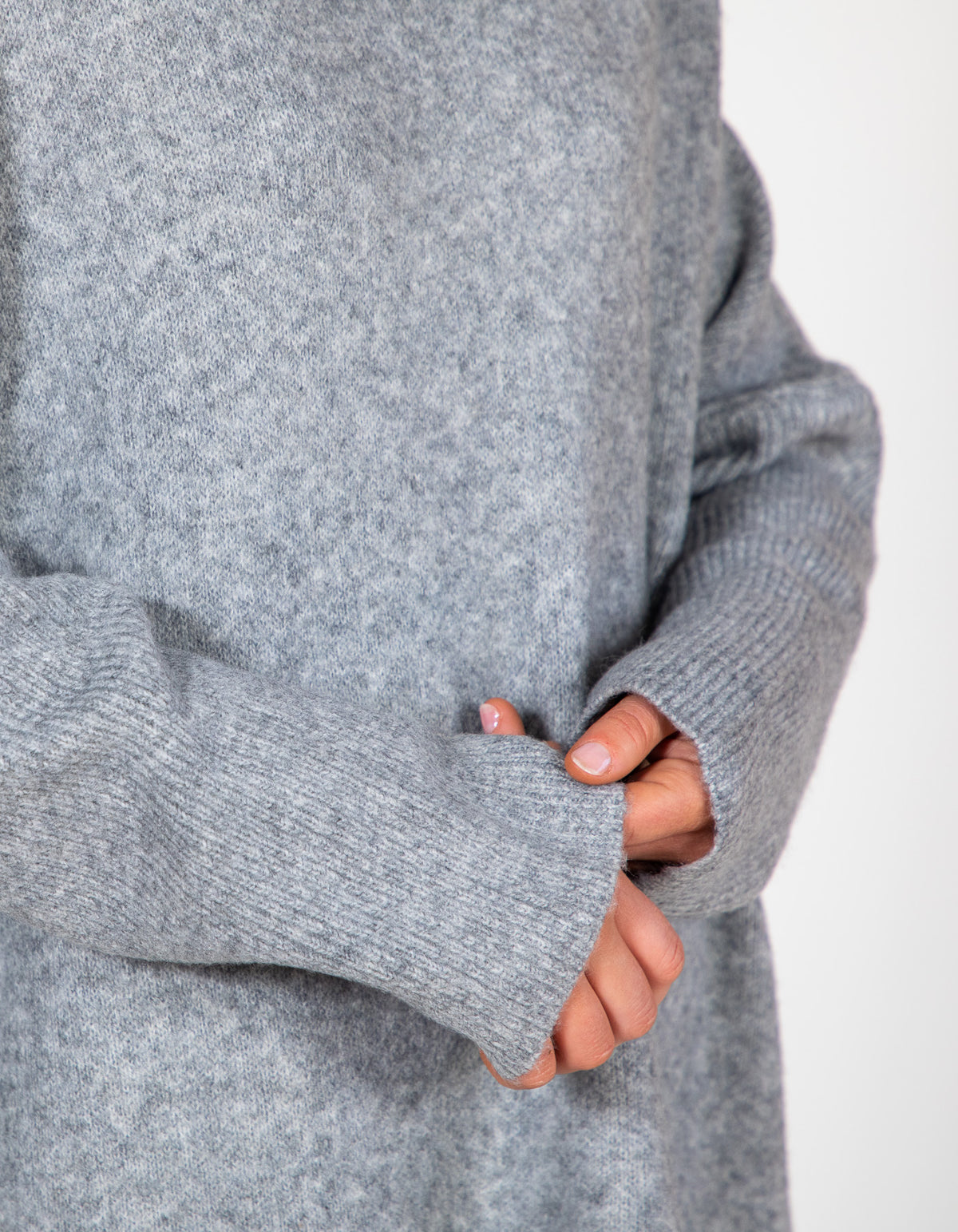 Grey oversized knit jumper highlighting a soft brushed finish and wide ribbed cuffs on the long sleeves.