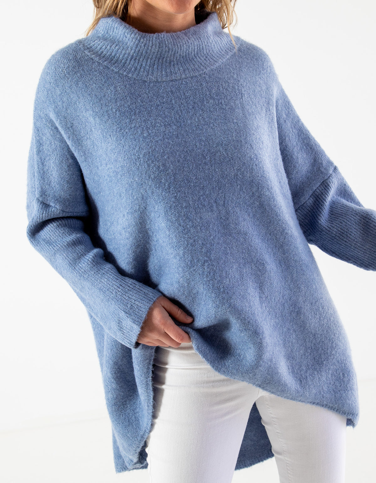 Front half-body shot of the blue oversized jumper showcasing the brushed knit finish and ribbed sleeves.