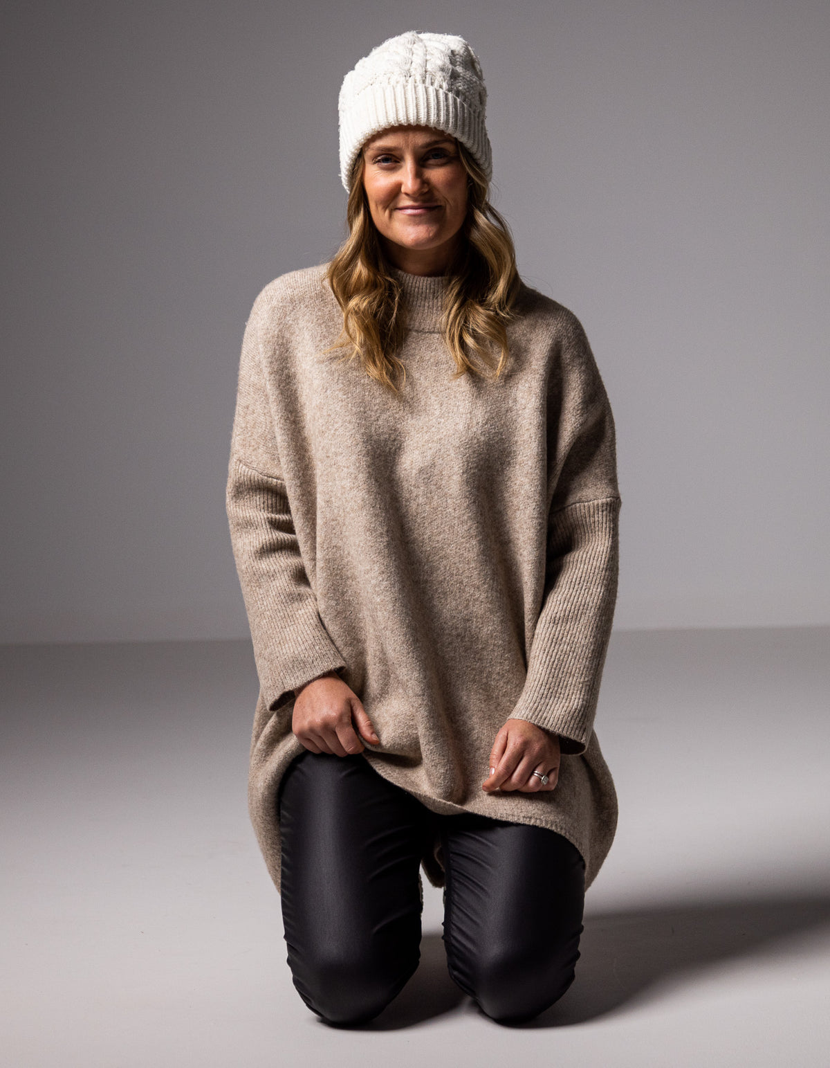 Full-body shot of the beige brushed knit jumper showcasing the relaxed fit through the torso and black pants.